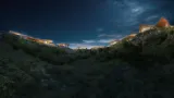 Mira Verde residences lit along the ridge under a night sky